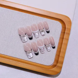 Handgemaakte ballerina cateye plaknagels met zwarte franse stippen en 3D-strikjes