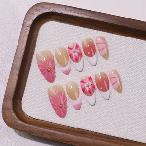 Handmade almond press-on nails with pink 3D flower carvings and pearl accents
