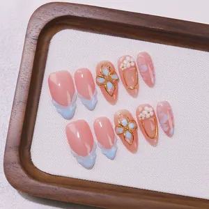 Handmade almond press-on nails with pink base, 3D white flowers, and gold hand-painted art