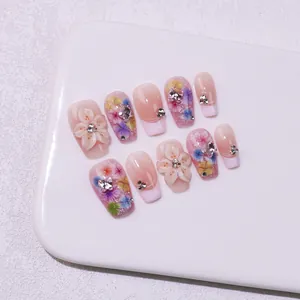 Handmade press-on nails with 3D floral accents and pink French gradient design