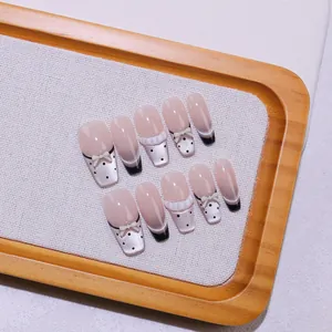 Detailopname van 10 handgemaakte balletnagels met 3D-strikjes en stippenpatroon