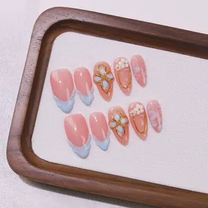Handmade almond press-on nails with pink base, blue french tips and resin flowers