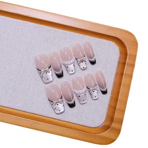 Handgemaakte cat-eye kunstnagels met kant, stippen en decoratieve 3D-strikjes
