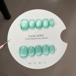 Short square mint green cat eye press-on nails with luxury shimmer finish on white display