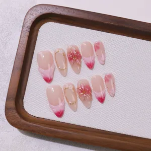 Pink almond press-on nails with hand-painted floral art and elegant pearl accents