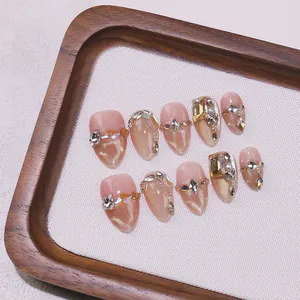 Handmade almond press-on nails with champagne gold glitter and luxury crystal jewelry