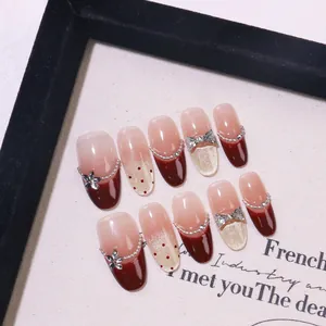 Handmade burgundy French cat-eye press-on nails with pink gradient and silver bows
