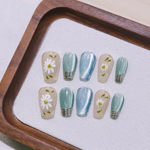 Unghie finte con fiori dipinti a mano, effetto cat-eye blu e dettagli metallici 3D argento