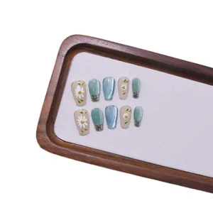 Squisite unghie finte fatte a mano con margherite dipinte e un effetto occhio di gatto blu