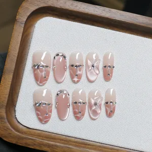 Faux ongles faits main rose poudré œil de chat avec papillon 3D et décorations strass