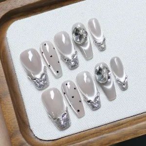 Cat eye press-on nails in long coffin shape with rhinestones and bow accents