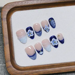 Handmade press-on nails with 3D floral designs and blue French gradient finish