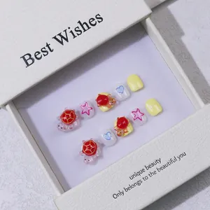 Handmade kids press-on nails featuring yellow and pink colors with cute 3D turtle and stars