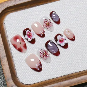 Handmade 3D floral press-on nails with cherry blossom design and gold rhinestone accents