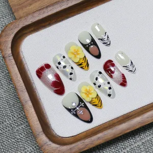 Faux ongles faits main avec motif tigre, fleurs 3D et breloques de croix en métal