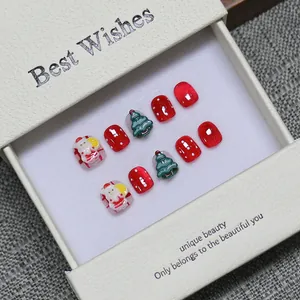 Handmade Christmas press-on nail set featuring 3D Santa and tree designs in a gift box