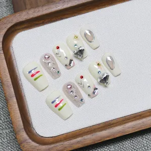 Handcrafted Y2K style press-on nails with rhinestones and hand-painted art on wooden tray