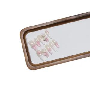 Handmade press-on nails set in pink and white with cute 3D bear and ribbon charms