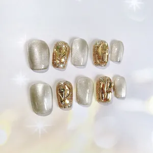 Handmade press-on nail kit featuring sparkling cat-eye effect and champagne gold rhinestones