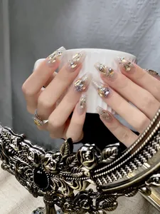 Detail van luxe coffin press-on nagels met champagne kristallen en roze verloop