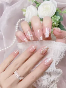 Close-up of handmade press-on nails with 3D embossed flowers and pearl accents