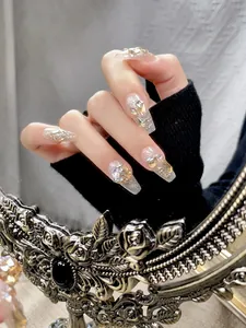Detail van handgemaakte kunstnagels met zilveren glitters en sprankelende kristallen