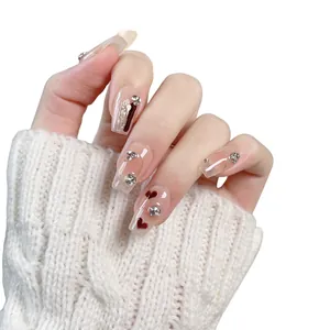Handgefertigte Herz-Nägel zum Aufkleben mit glitzernden Strasssteinen und Nude-Basis