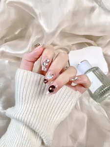 Macro detail of red rhinestone and pearl accents on luxury gradient coffin fake nails