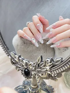 Detail of almond-shaped press-on nails with silver glitter, rhinestones and 3D bows