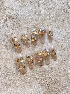 Detailweergave van handgemaakte lange coffin nagels met luxe aurora strassteentjes