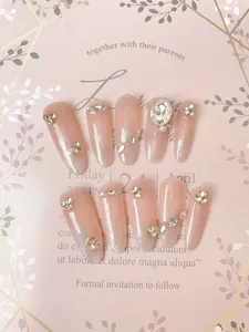 Detail of pink gradient handmade press-on nails with sparkling rhinestones and pearls
