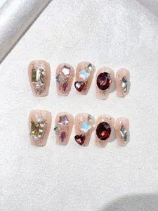 Detailed macro view of handmade press-on nails with luxury gems and aurora butterfly