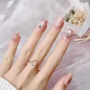 Handmade pink cat-eye press-on nails with 3D butterfly charms and gold wave lines