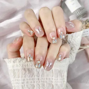 Pink press-on nails with 3D butterfly, shells and heart charms on satin fabric