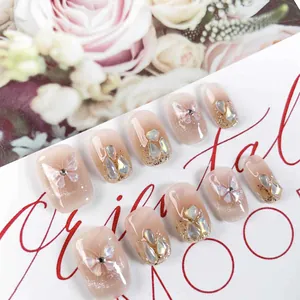 Handmade gradient pink press-on nails with butterfly motifs and sparkling rhinestones