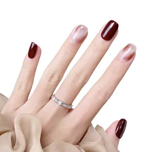 Kurze ovale künstliche Nägel in Dunkelrot und Marmor-Look mit silbernem Diamantring