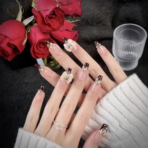 Unghie finte French ombre bordeaux con fiocchi 3D, strass e dettagli in foglia d'oro
