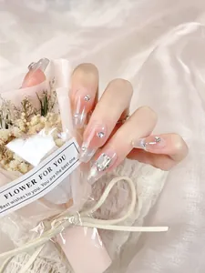Detail of pink gradient press-on nails with sparkling rhinestones and silver glitter
