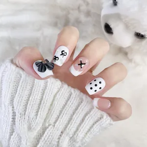 Handmade black and white press-on nails with 3D bows, pearls, and French patterns