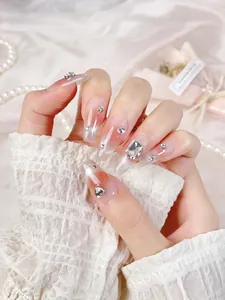Macro detail of long ballerina press-on nails with pink gradient and luxury rhinestones