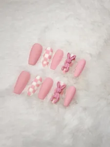 Close-up of pink checkered press-on nails with 3D cute rabbit charms on soft faux fur