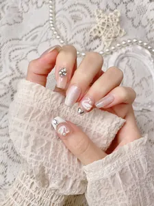 Close-up of handmade press-on nails featuring white swan relief and cat-eye glitter