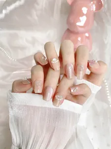 Vue détaillée des faux ongles perles roses avec effet oeil de chat scintillant et strass 3D