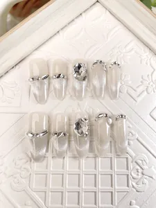 Detail of long almond press-on nails with silver cat-eye effect and 3D rhinestones
