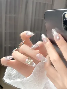 Detail of long coffin press-on nails with silver cat eye effect and golden butterfly charm