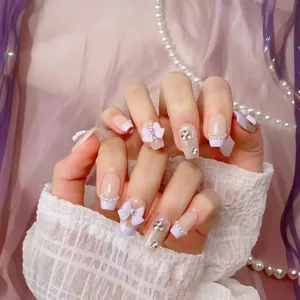 Handmade purple french press-on nails with white bows, pearls, and sparkling rhinestones