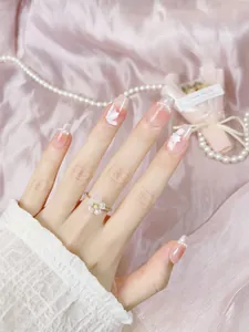 Detailed view of handmade nude gradient press-on nails with 3D white flowers and pearls