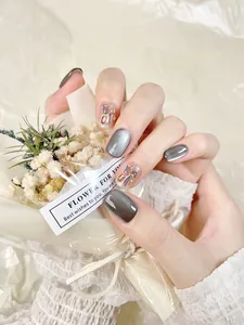 Détails des faux ongles œil-de-chat gris foncé avec des strass colorés et paillettes