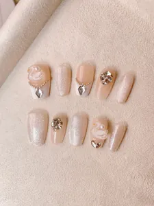 Detailed view of handmade swan cat-eye nails with pearls and rhinestones decoration