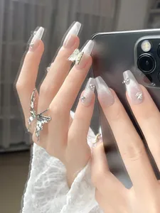 Detail of silver cat eye nails with sparkling rhinestones and metal butterfly accents